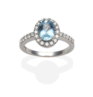 Lot 2129 - An 18 Carat White Gold Aquamarine and Diamond Cluster Ring, an oval cut aquamarine in a four...