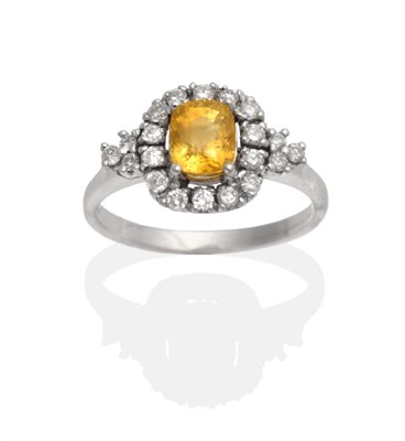 Lot 2036 - An 18 Carat White Gold Yellow Sapphire and Diamond Ring, an oval cut yellow sapphire in a claw...