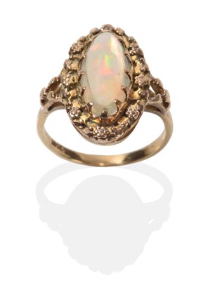 Lot 2042 - An Arts & Crafts Opal Ring, an oval opal in a claw setting within a border of small flower...