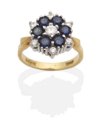 Lot 2087 - An 18 Carat Gold Sapphire and Diamond Cluster Ring, a round brilliant cut diamond within a...