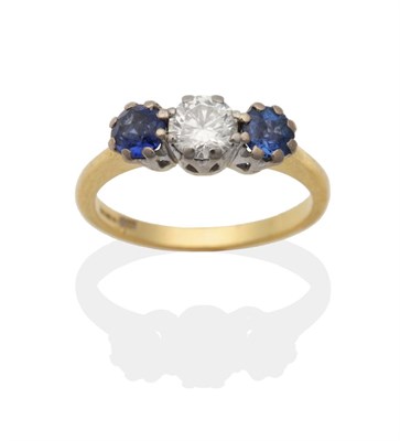 Lot 2089 - An 18 Carat Gold Diamond and Synthetic Sapphire Three Stone Ring, a round brilliant cut diamond...