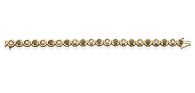 Lot 2101 - An Emerald and Diamond Line Bracelet, alternating round cut emeralds and round brilliant cut...