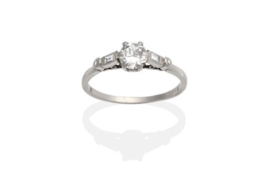 Lot 2106 - A Diamond Solitaire Ring, a round brilliant cut diamond in a claw setting to shoulders each set...