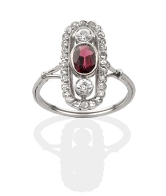 Lot 2116 - An Art Deco Garnet and Diamond Cluster Ring, an oval cut garnet between two old cut diamonds...