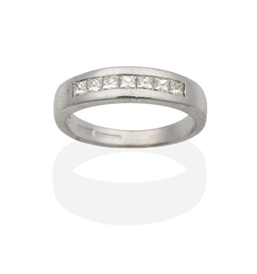 Lot 2035 - An 18 Carat White Gold Diamond Half Hoop Ring, seven channel set princess cut diamonds, total...