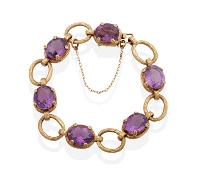 Lot 2068 - A 9 Carat Gold Amethyst Bracelet, oval cut amethyst in textured frames spaced by textured oval...