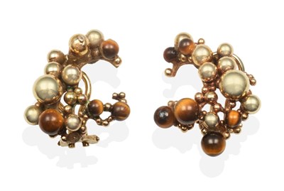 Lot 2078 - A Pair of Tiger's Eye Clip Earrings, of abstract form with beaded detail and interspersed with...