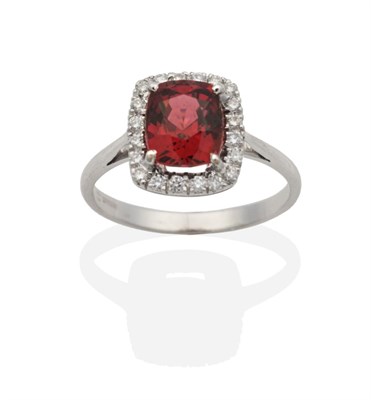 Lot 2090 - An 18 Carat White Gold Garnet and Diamond Cluster Ring, a cushion cut garnet in a claw setting...