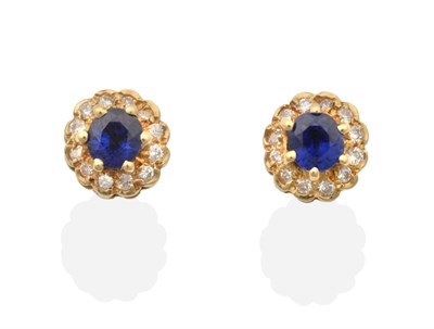 Lot 2107 - A Pair of 18 Carat Gold Sapphire and Diamond Cluster Earrings, an oval cut sapphire within a border