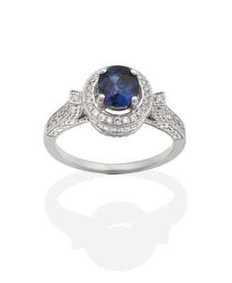 Lot 2122 - A Sapphire and Diamond Cluster Ring, an oval cut sapphire in a claw setting within a diamond...