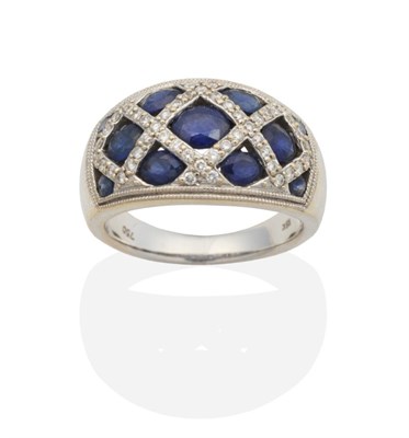 Lot 2125 - A Sapphire and Diamond Ring, the domed top inset with graduated oval cut sapphires in diamond...