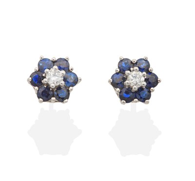 Lot 2127 - A Pair of Diamond and Sapphire Cluster Earrings, a round brilliant cut diamond within a border...