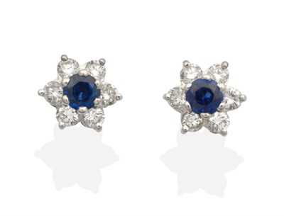 Lot 2133 - A Pair of Sapphire and Diamond Cluster Earrings, a round cut sapphire within a border of round...