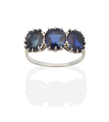 Lot 2135 - A Sapphire Three Stone Ring, graduated oval cut sapphires in claw settings, to knife edge...