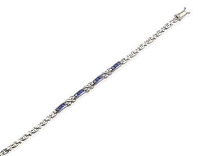 Lot 2137 - A Sapphire and Diamond Bracelet, calibré cut sapphires spaced by infinity loop links inset...