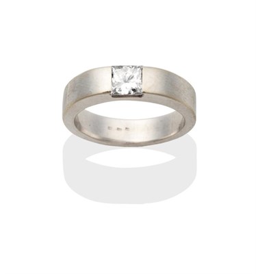 Lot 2000 - A Princess Cut Solitaire Diamond Ring, channel set to a tapering flat sided shank, estimated...