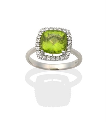 Lot 2003 - An 18 Carat White Gold Peridot and Diamond Cluster Ring, a cushion cut peridot in a claw...