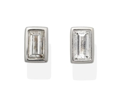 Lot 2025 - A Pair of 18 Carat White Gold Baguette Cut Solitaire Diamond Earrings, in rubbed over settings,...