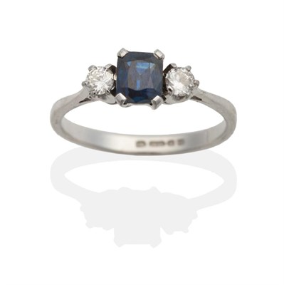 Lot 2036 - An 18 Carat White Gold Sapphire and Diamond Three Stone Ring, an octagonal cut sapphire in a...