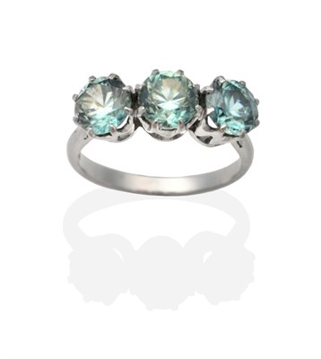 Lot 2043 - A Three Stone Blue Zircon Ring, round cut blue zircon in claw settings, to knife edge...