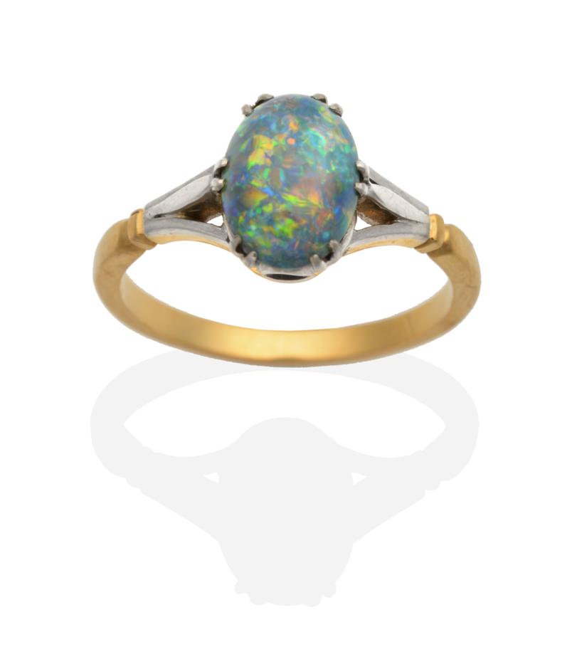 Lot 2046 - A Black Opal Ring, an oval cabochon black opal in a double claw setting, to forked shoulders,...