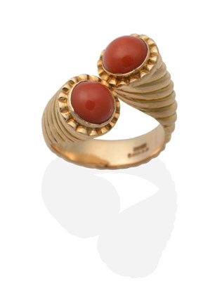 Lot 2095 - A 14 Carat Gold Coral Torque Ring, two round cabochon coral in rubbed over settings, to a...