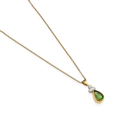 Lot 2100 - An 18 Carat Gold Green Tourmaline and Diamond Pendant, on Chain, a pear cut green tourmaline in...