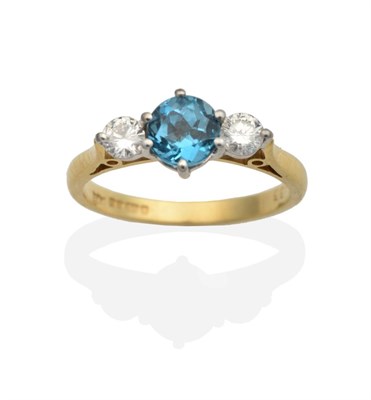 Lot 2114 - An 18 Carat Gold Blue Topaz and Diamond Three Stone Ring, a round cut blue topaz in a claw setting