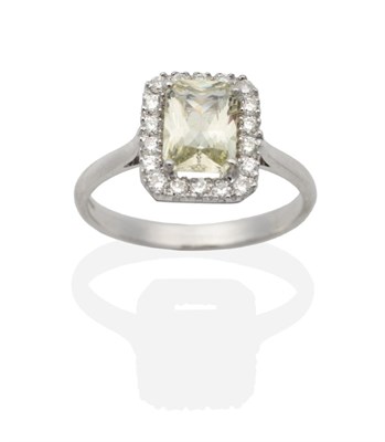 Lot 2129 - An 18 Carat White Gold Pale Yellow Sapphire and Diamond Cluster Ring, a radiant pale yellow...