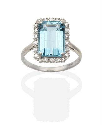 Lot 2133 - An Aquamarine and Diamond Cluster Ring, an octagonal cut aquamarine in a claw setting, within a...