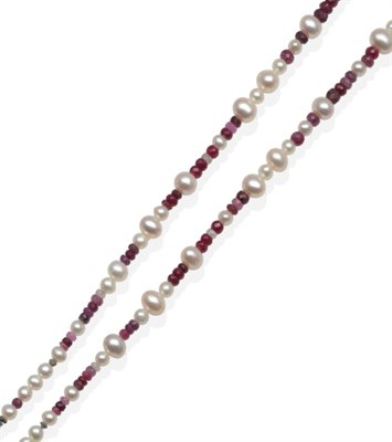 Lot 2154 - A Ruby and Cultured Pearl Necklace, graduated faceted shaded ruby beads spaced at intervals by...