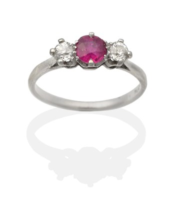 Lot 2162 - A Ruby and Diamond Three Stone Ring, a round cut ruby in a claw setting, spaced by old cut...