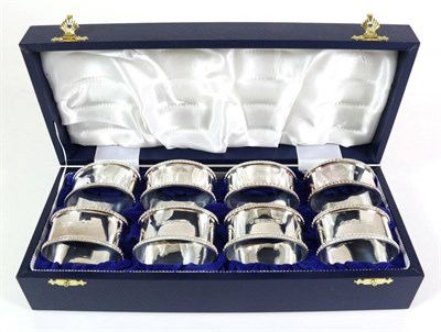 Lot 2280 - A Set of Eight Silver Napkin Rings, JBF, Sheffield 2000, with bead borders, in a fitted case,...