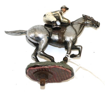 Lot 2081 - A 1930s Chromed and Painted Car Mascot as a Jockey on Horseback, on a green painted circular...