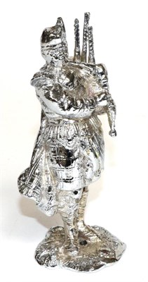 Lot 2090 - A Chrome Car Mascot Modelled as a Scottish Piper, standing on a rocky base with drill hole,...
