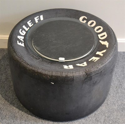 Lot 1056 - A Coffee Table in the Form of a Goodyear Eagle F1 26 X 15 X 13 Tyre, with glass top and...