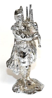 Lot 1096 - A Chrome Car Mascot Modelled as a Scottish Piper, standing on a rocky base with drill hole,...