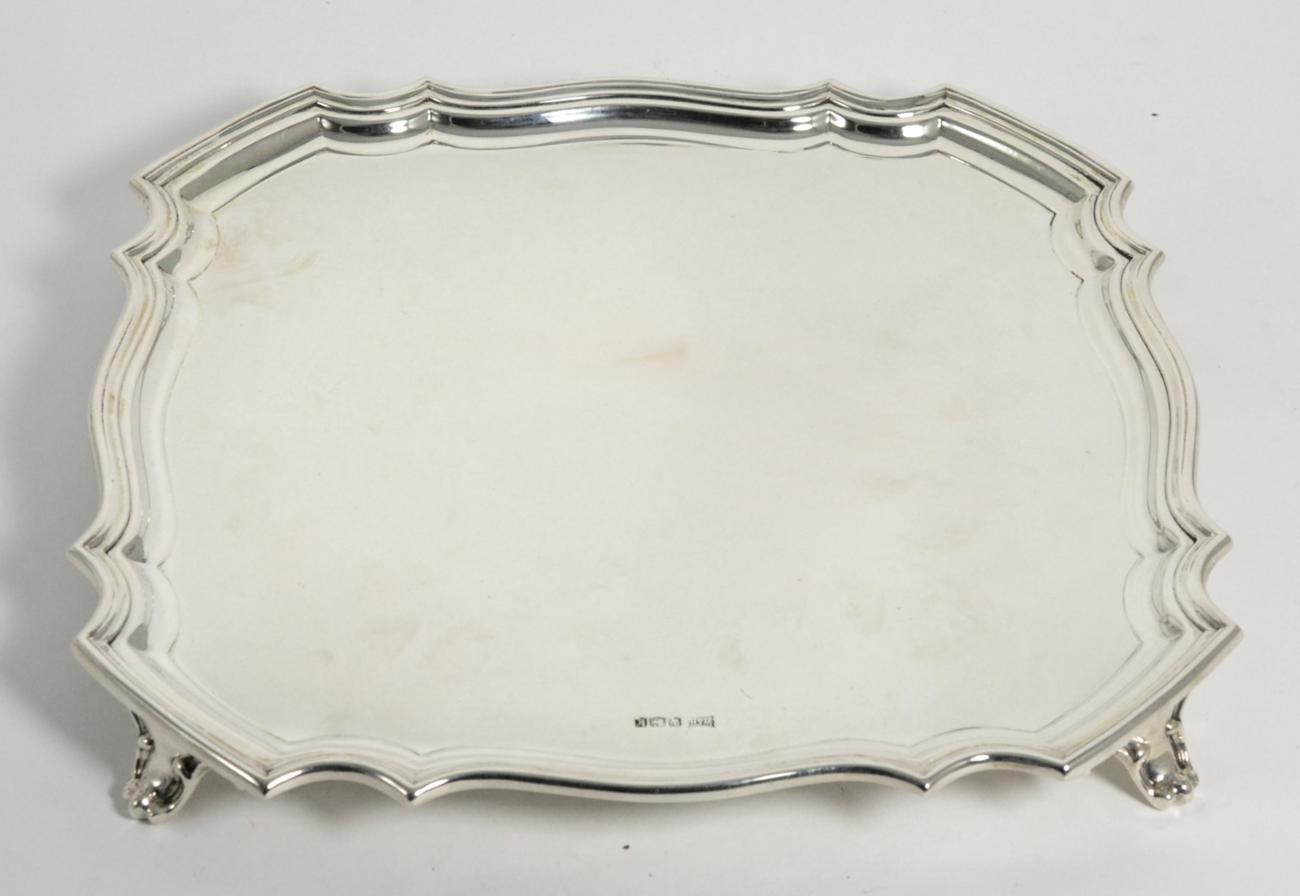 Lot 126 - A Shaped Square Silver Salver, Walker & Hall, Sheffield 1927, standing on four bracket feet,...