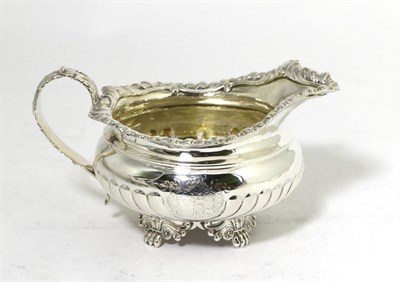 Lot 292 - A George IV Silver Cream Jug, maker's mark rubbed, London 1821, squat circular with part fluted...