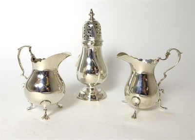 Lot 306 - A Georgian style silver caster, Sheffield 1929; and two 18th Century style silver cream jugs,...