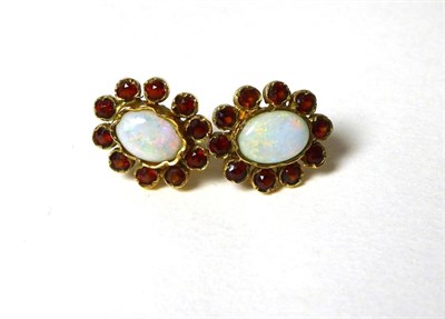 Lot 352 - A pair of opal and hessonite garnet cluster earrings, an oval cabochon opal in a collet...
