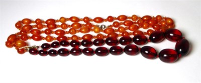 Lot 380 - A bakelite bead necklace, of graduated clear oval beads, 47cm long and an orange plastic bead...