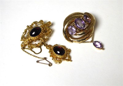 Lot 384 - A 9 carat gold Victorian revival garnet brooch, a cabochon cut garnet within a foliate...