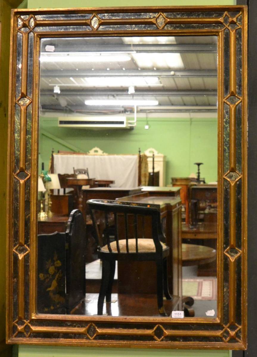 Lot 1151 - A rectangular gilt and verre eglomise framed wall mirror