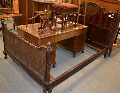 Lot 1166 - A French mahogany bergere double bedstead, with leaf and ribbon carved head board and foot rail and