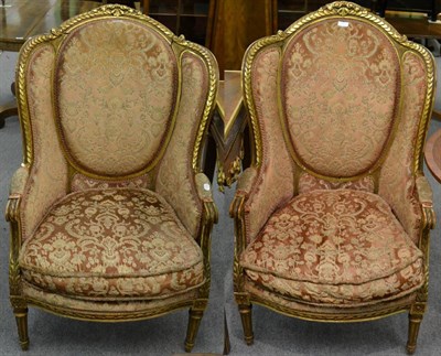 Lot 1176 - A pair of carved gilt wood wingback armchairs
