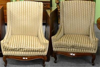 Lot 1185 - A pair of upholstered armchairs, 20th century, on cabriole scroll supports, in striped fabric