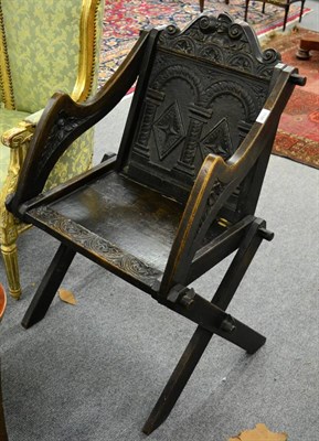 Lot 1188 - A carved oak Bishop's chair, with scrolled and lunette carved top rail above a fielded back support