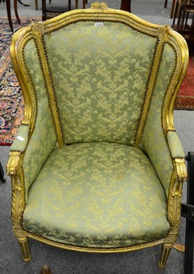 Lot 1189 - A carved gilt wood upholstered armchair, fluted supports and green foliate fabric