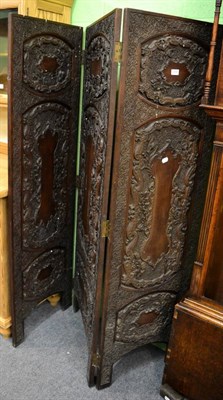 Lot 1259 - A late 19th century Indian hardwood three-leaf dressing screen, carved overall with a border of...